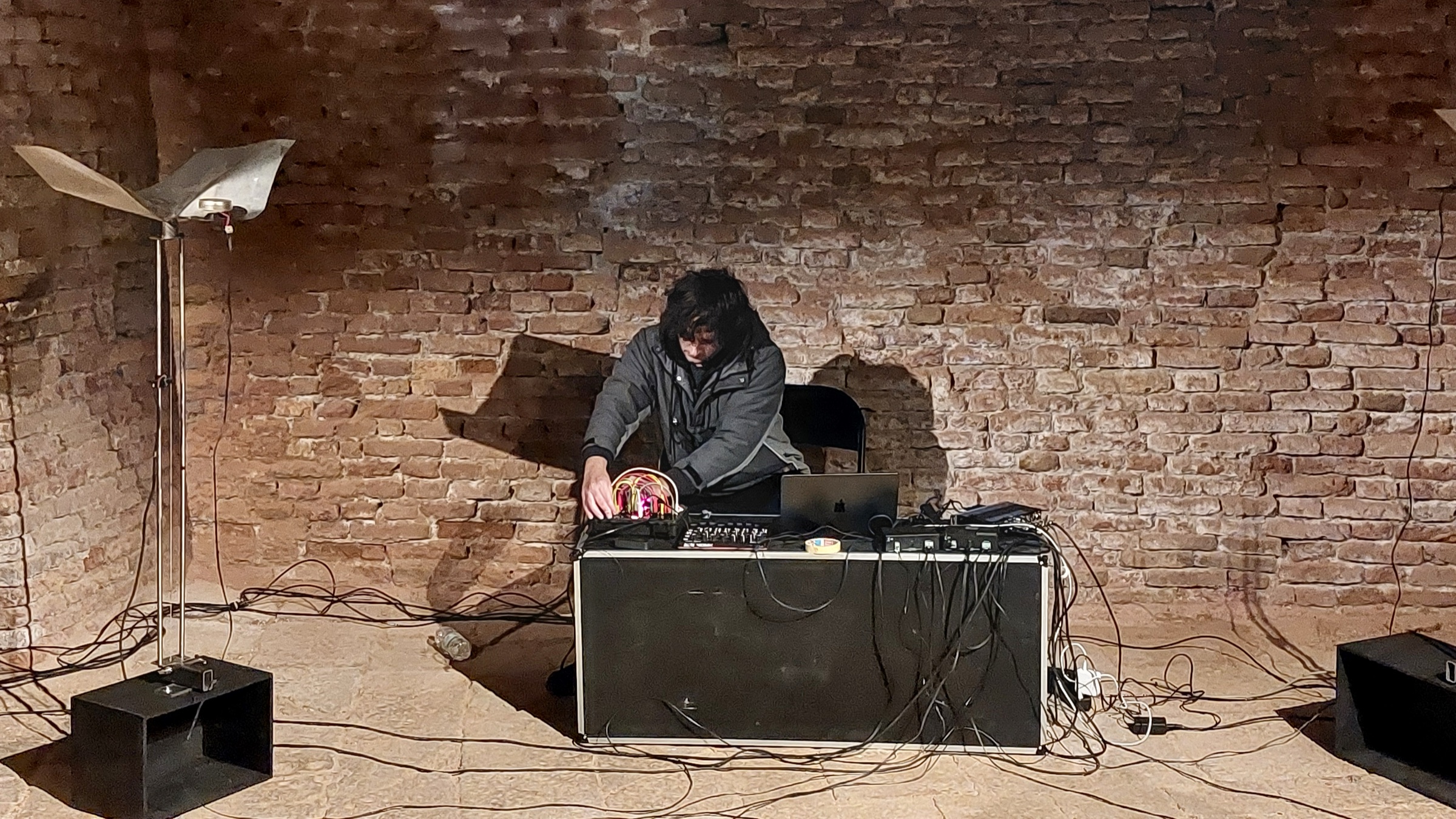 Daniele Pozzi performing Autotropo with a modular synthesizer in a brick-walled space
